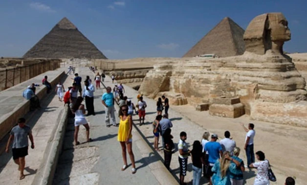 Tourists take pictures at the Sphinx and the Pyramids of Giza in Cairo. (Reuters)