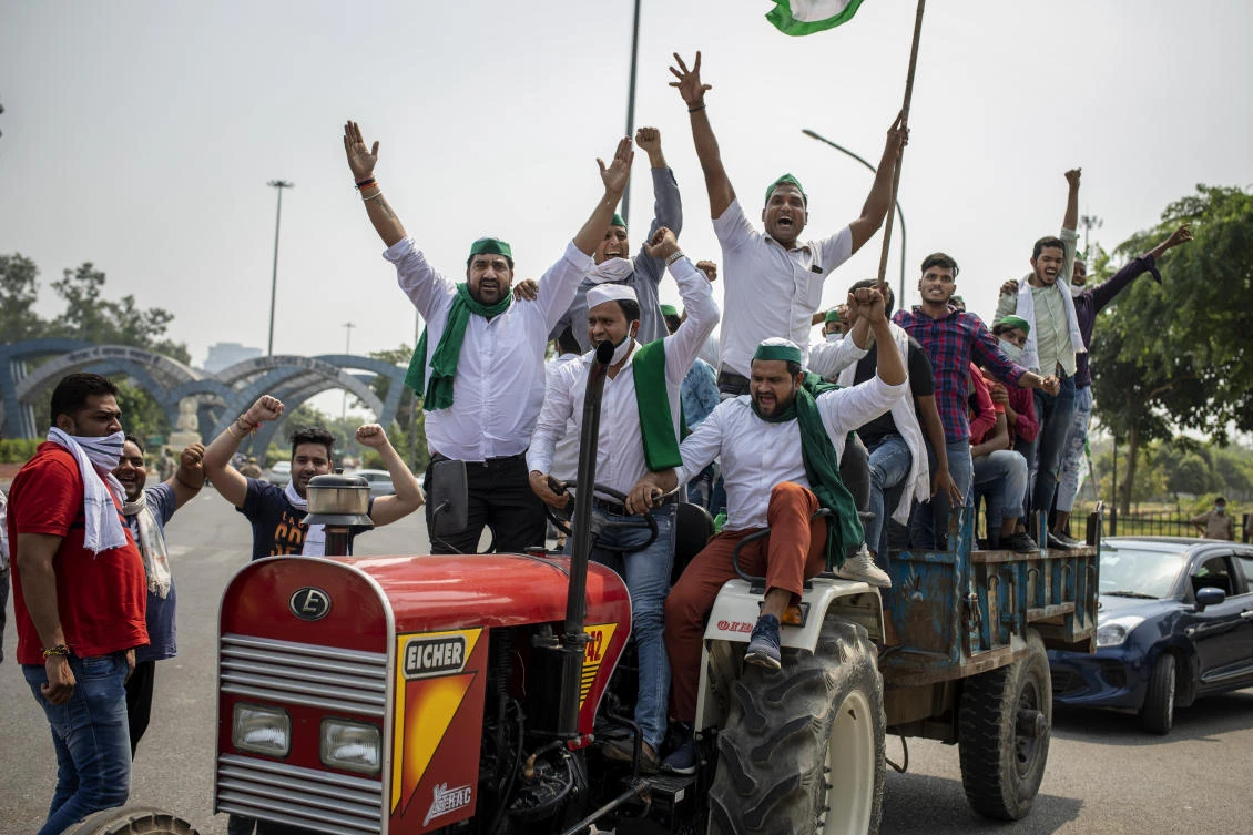 Indian farmers shout slogans as they ride tractors towards New Delhi in Noida, India, Friday, Sept. 25, 2020. (AP)