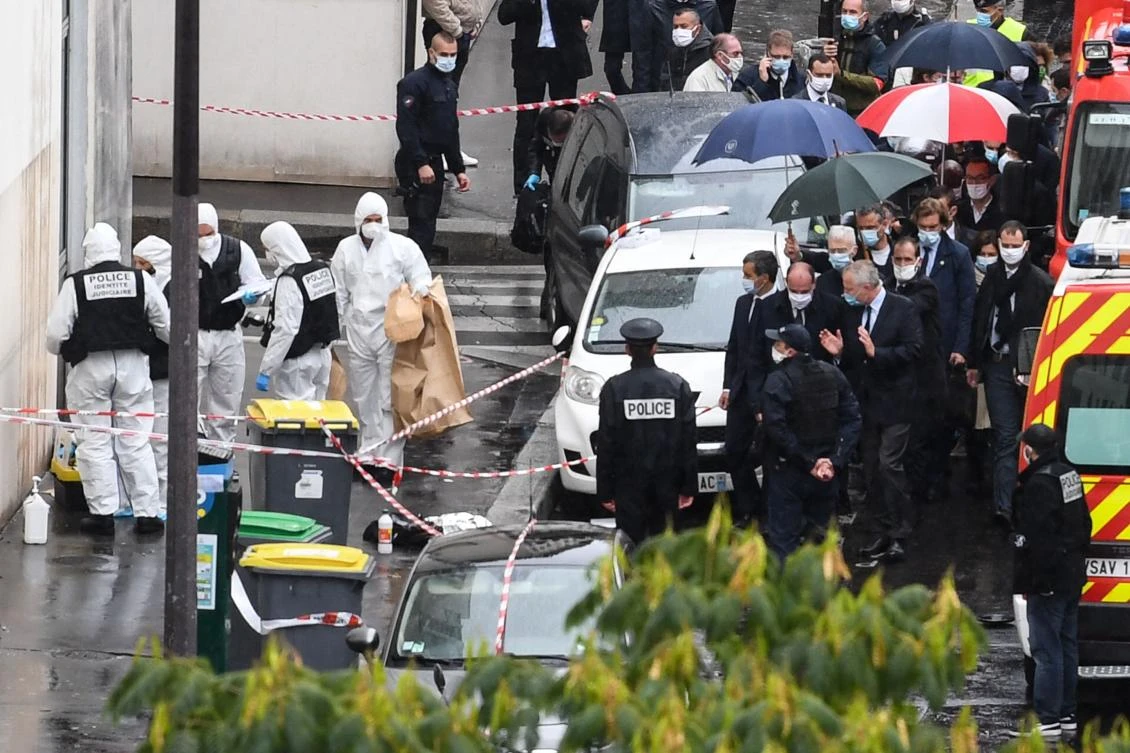 French Prime Minister Jean Castex (C) and French Interior Minister Gerald Darmanin (C-L) arrive at the scene where several people were injured near the former offices of French magazine Charlie Hebdo following an attack by a man in Paris on Sept. 25, 2020. (AFP)