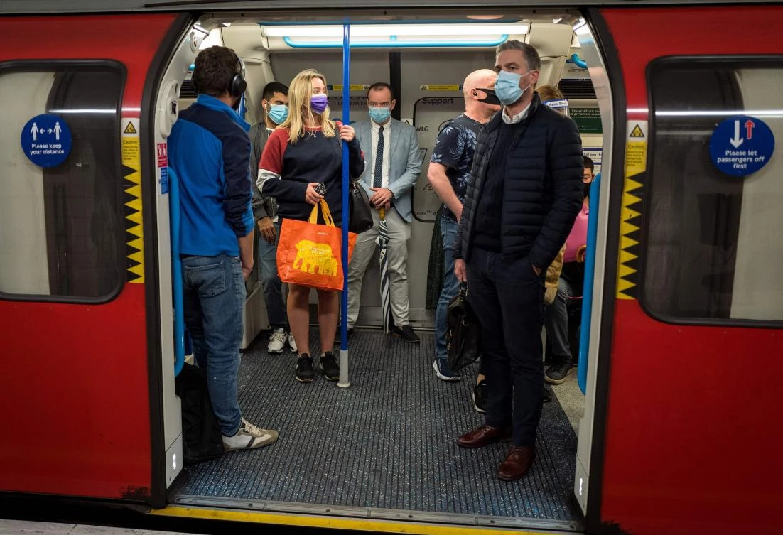 Commuters wearing face masks or covering due to the COVID-19 pandemic, stand aboard a Victoria Line London underground tube train as they travel during the evening 'rush hour' in central London on September 23, 2020. (AFP)
