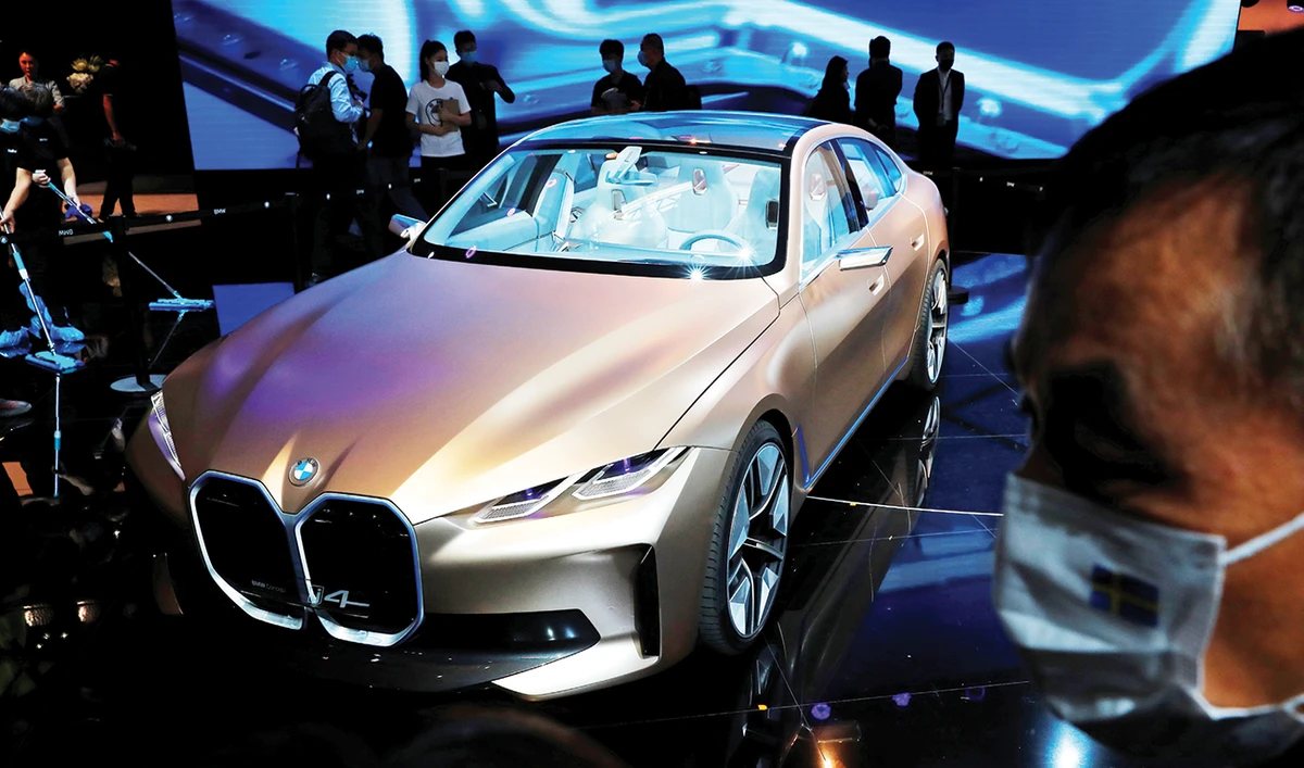 Visitors inspect a BMW i4 concept car at the Beijing autoshow, a rare industry event held in person during the pandemic, which fewer people attended and where new models were scant. (Reuters)
