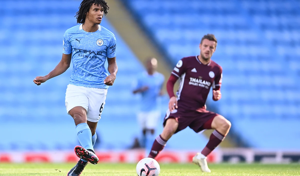 Manchester City’s Nathan Ake, left, passes the ball watched by Leicester’s Jamie Vardy during the soccer match in Manchester, England, on Sunday. (AP)