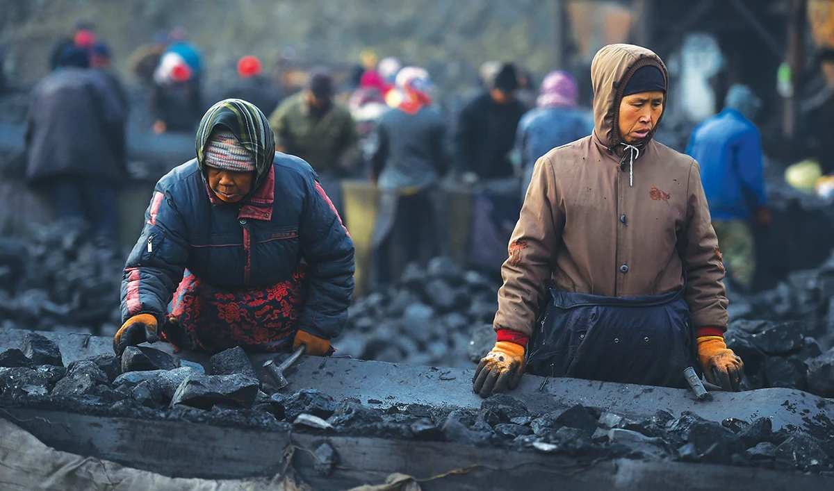 Workers sort coal on a conveyer belt in Shanxi. China’s surprise pledge to slash its carbon footprint to zero by 2060 was met with cautious applause. (AFP)
