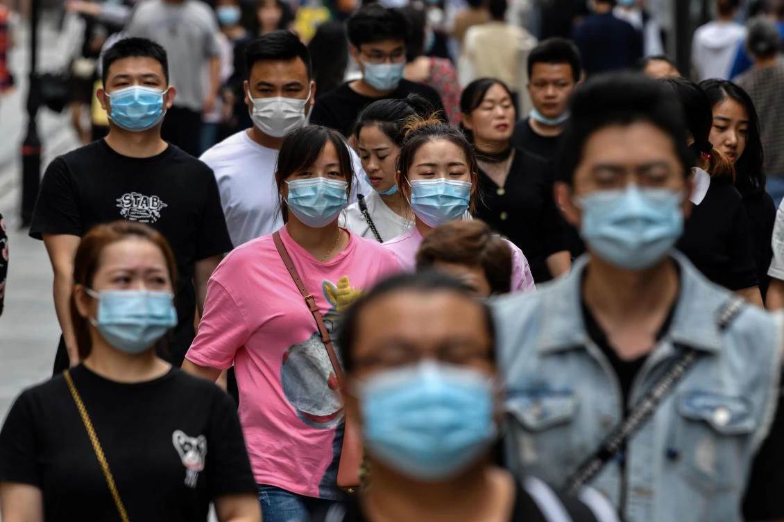 People wearing face masks as a preventive measure against the COVID-19 coronavirus walk on a pedestrian street in Wuhan, in China’s central Hubei province on September 27, 2020. (File/AFP)