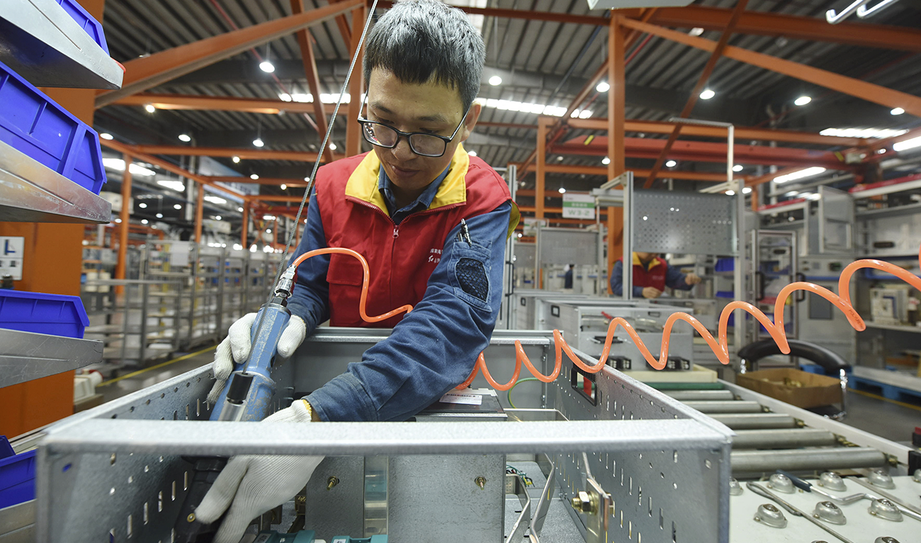 A worker installs a power distribution cabinet in a subsidiary of the State Grid in Hangzhou in east China's Zhejiang province on Oct. 19, 2020. (AP)