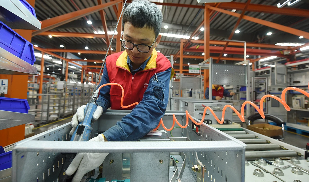 A worker installs a power distribution cabinet in a subsidiary of the State Grid in Hangzhou in east China's Zhejiang province on Oct. 19, 2020. (AP)