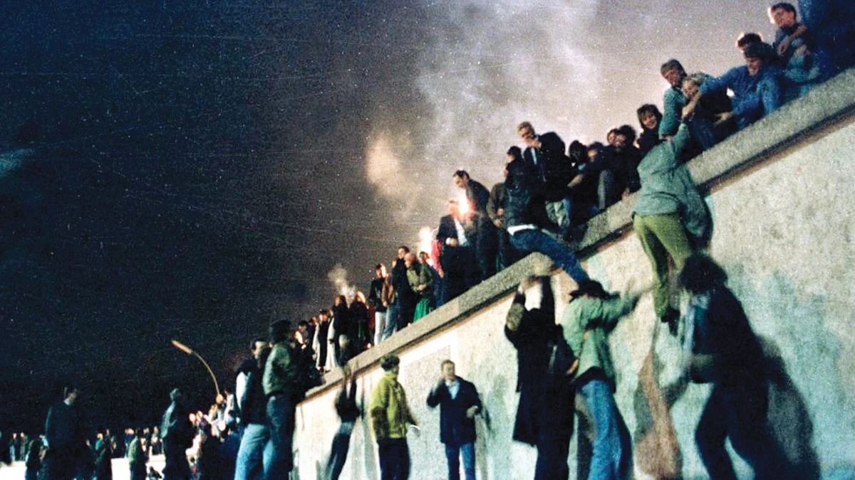 East German citizens climb the Berlin Wall in 1989. The fall of the Berlin Wall in November 1989 was followed by the reunification of Germany on Oct. 3, 1990. (File/Reuters)