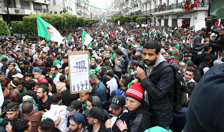 Algerians, waving national flags, march during an anti-government demonstration in Algiers, as the country is readying for a constitutional referendum. (AFP)