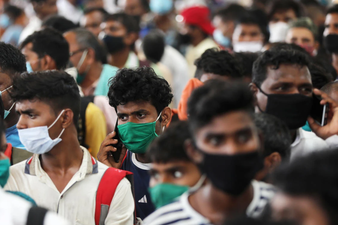 Migrants who returned from their hometown of Uttar Pradesh wait in line to be tested for the coronavirus at a railway station on the outskirts of Mumbai on Oct. 3, 2020. (Reuters)