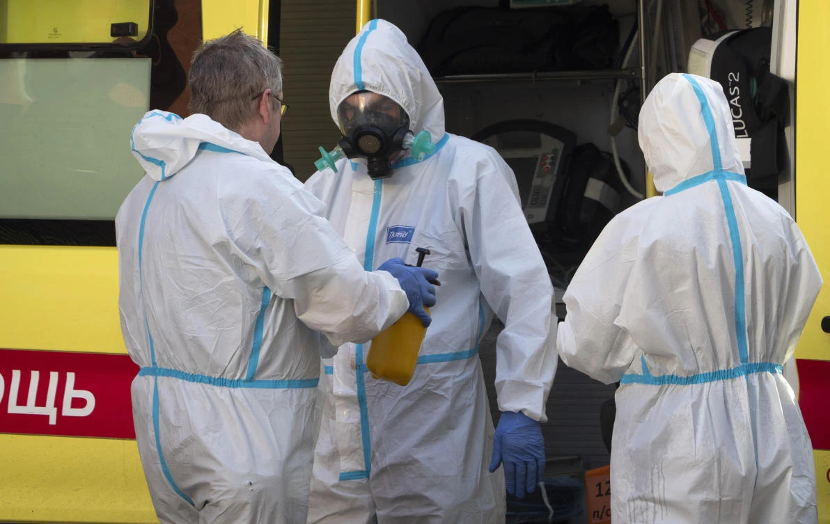 A medical worker wearing protective gear to protect against coronavirus infection disinfects his colleague after escorting a patient by ambulance to a hospital for COVID-19 patients in St.Petersburg, Russia, Thursday, Oct. 1, 2020. (AP)