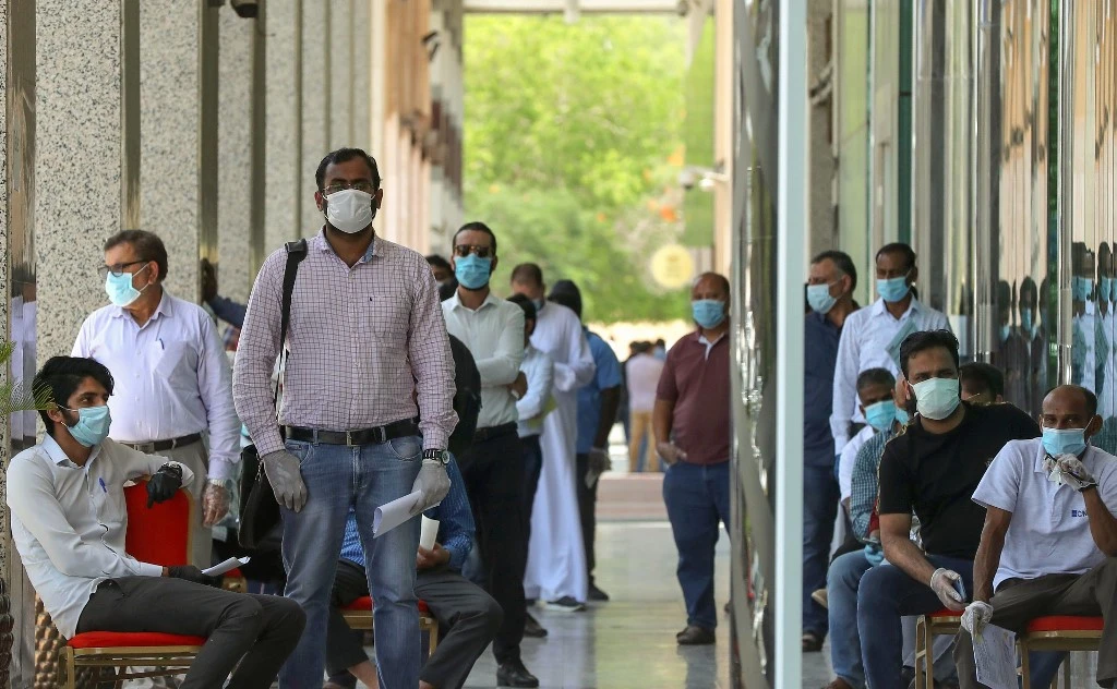People queue for services in Doha in May as the country was hit by high COVID-19 rates. (AFP/File)