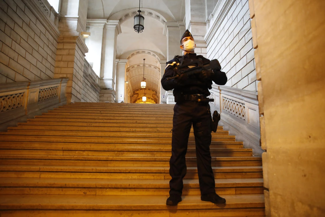 A riot police officer guards the stairs leading to the court before the trial of a 29-year-old Algerian man accused of killing a woman and trying to blow up a church near Paris, a failed 2015 attack that investigators say was orchestrated by Daesh extremists in Syria. (AP)