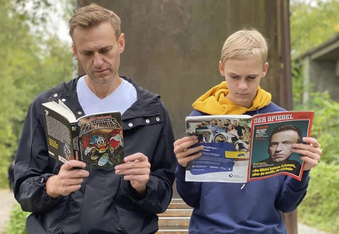 Alexei Navalny, left, reads ‘Ultimate Phantomias’ as his son Zahar reads the German news magazine Der Spiegel with a portrait of Navalny on the cover, Saturday, Oct. 3, 2020. (AP Photo)