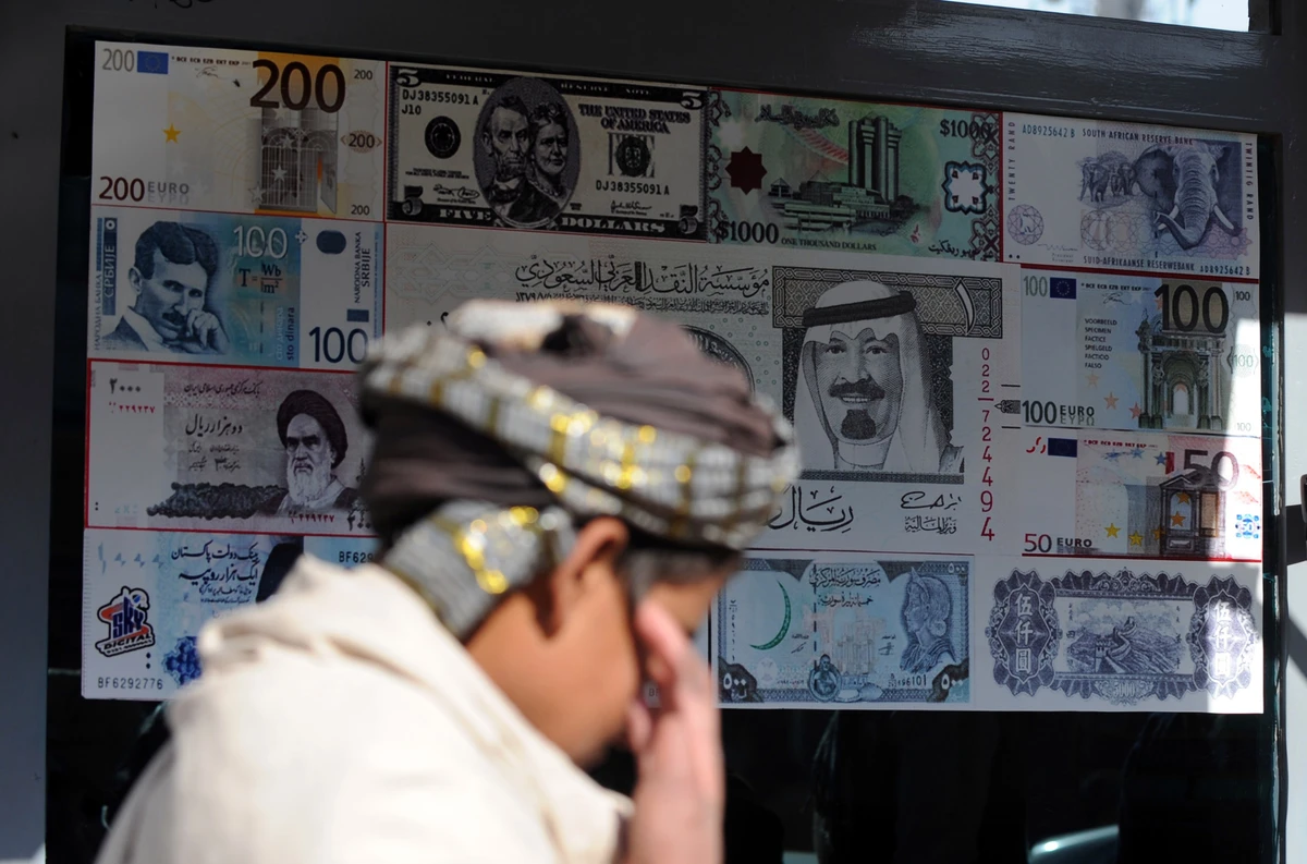 A pedestrian walks past a foreign currency exchange shop in Quetta on December 8, 2011. (AFP)
