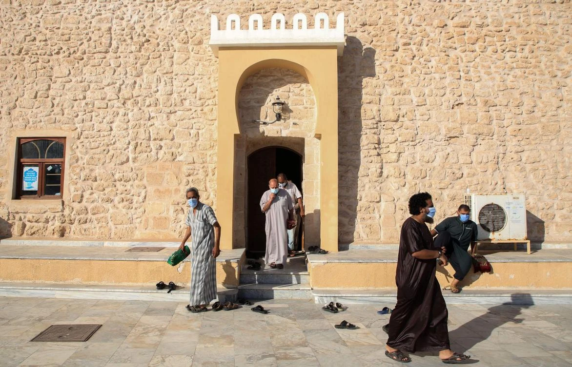 Mask-clad Libyan Muslim worshippers leave the Murad Agha Mosque in the city of Tajura, southeast of the capital Tripoli, after performing the dusk prayers following the easing of restrictions by the authorities, that had been imposed in a bid to stem the spread of the coronavirus, on October 9, 2020. (AFP)
