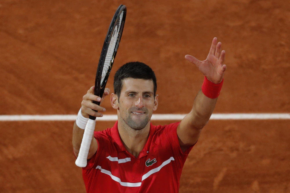 Serbia's Novak Djokovic celebrates winning his semifinal match of the French Open tennis tournament against Greece's Stefanos Tsitsipas in five sets, 6-3, 6-2, 5-7, 4-6, 6-1, at the Roland Garros stadium in Paris on Oct. 9, 2020. (AP Photo/Christophe Ena)