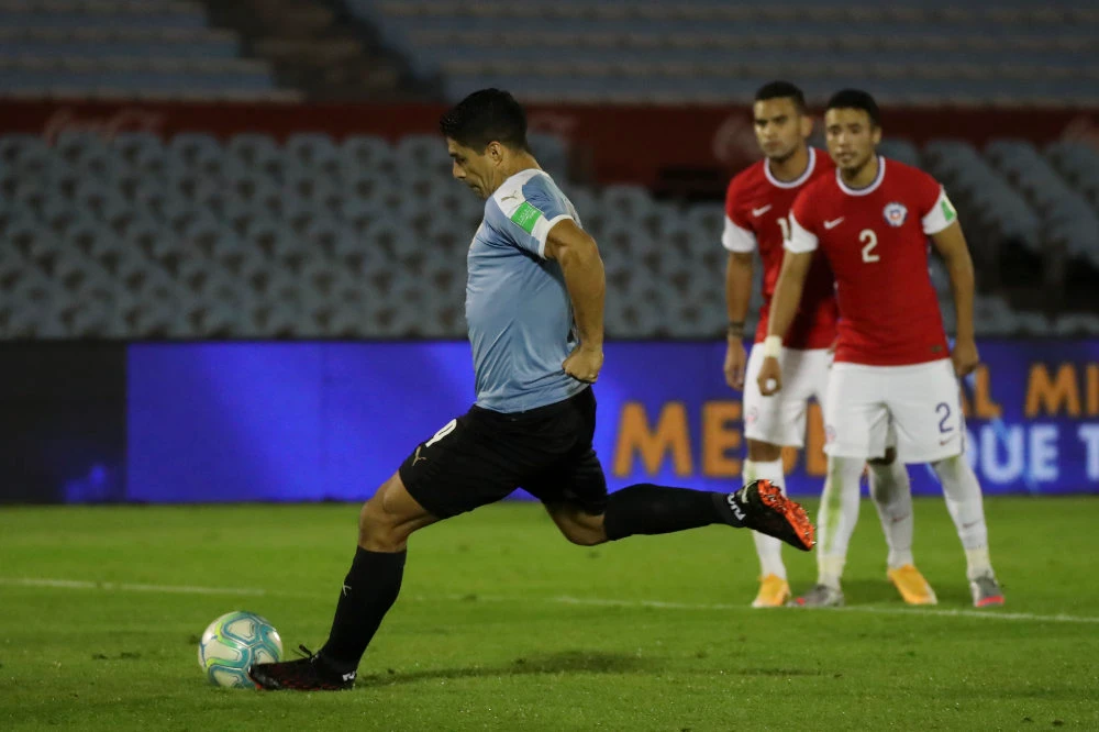 Uruguay's Luis Suarez scores from the penalty point the opening goal during a qualifying soccer match for the FIFA World Cup Qatar 2022 against Chile at the Centenario stadium in Montevideo, Uruguay, on Oct. 8, 2020. (Raul Martinez/Pool via AP)