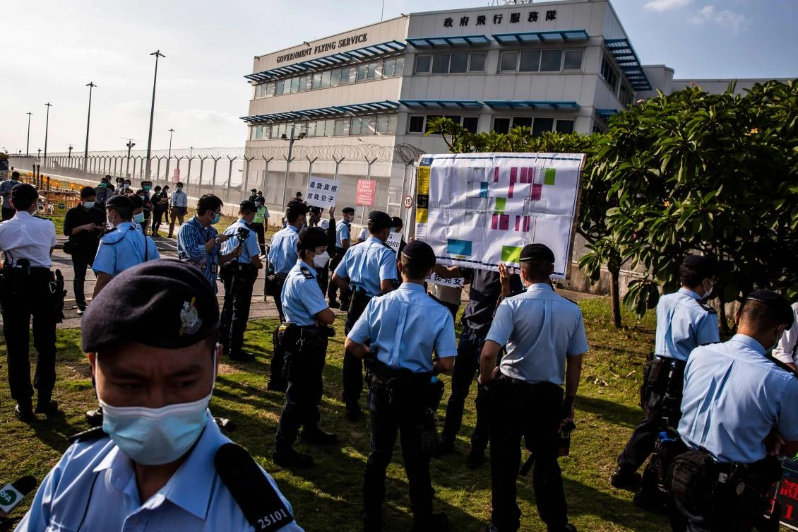 Police break up a protest by family members of 12 Hong Kong residents, who were intercepted and detained by the Chinese coast guard after trying to flee for Taiwan, outside a government office on Oct. 10, 2020. (AFP)