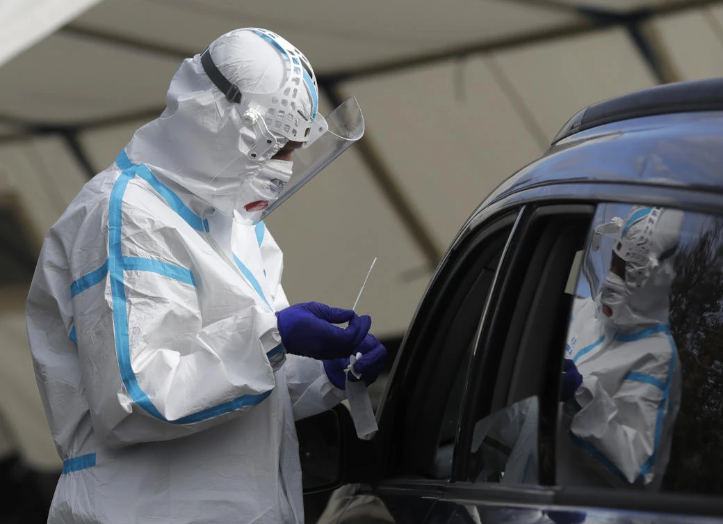 A healthcare worker conducts a COVID-19 test at a drive-in sampling station in Prague on Oct. 7, 2020. The Czech health ministry said the reported 8,618 new cases on Friday (AP)