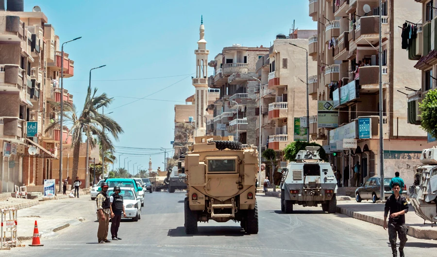A picture taken on July 27, 2018 shows Egyptian policemen driving on a road leading to the North Sinai provincial capital of El-Arish. (AFP)