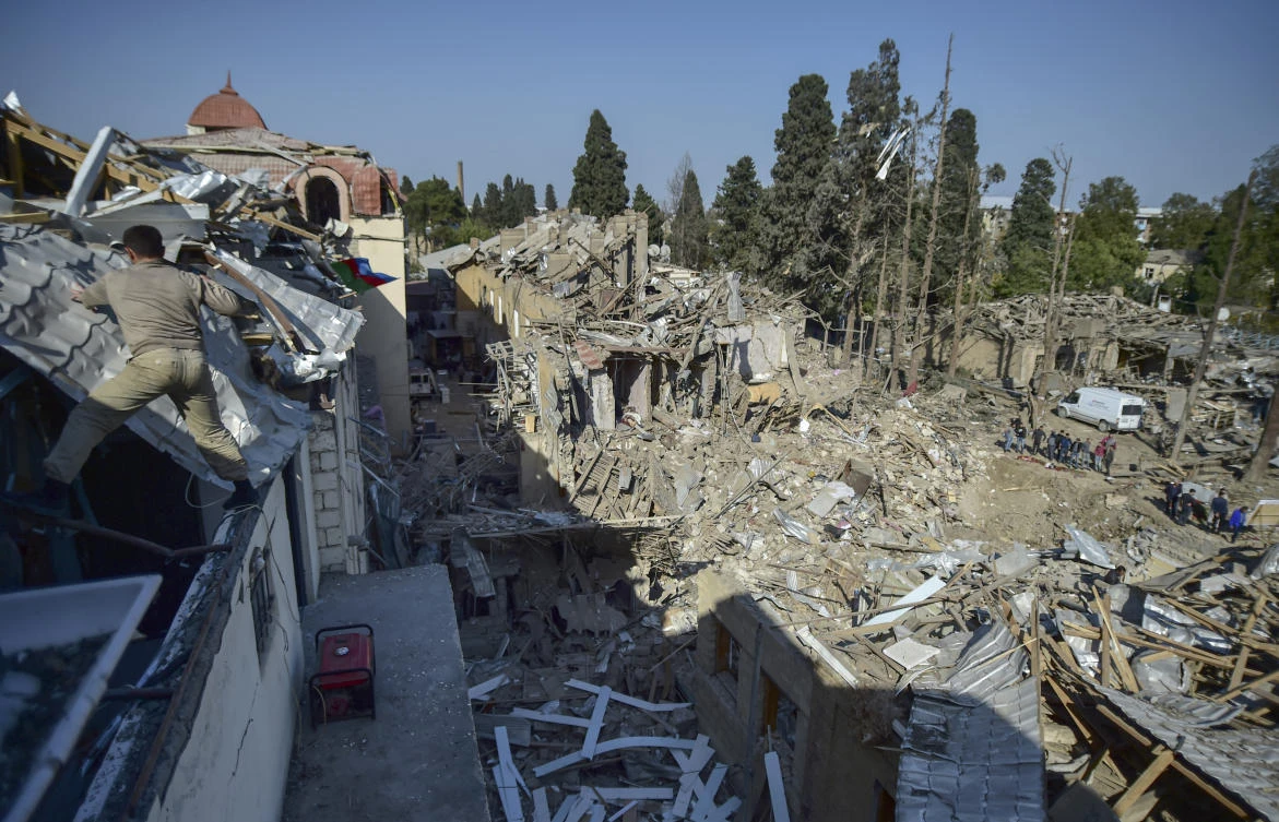 People look at the destroyed houses a day after shelling by Armenian's artillery during fighting over the separatist region of Nagorno-Karabakh, in Ganja, Azerbaijan, Monday, Oct. 12, 2020. (AP Photo)