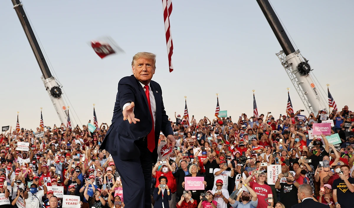 US President Donald Trump throws a face mask from the stage during a campaign rally, his first since being treated for the coronavirus disease (COVID-19), at Orlando Sanford International Airport in Sanford, Florida, US, October 12, 2020. (Reuters)