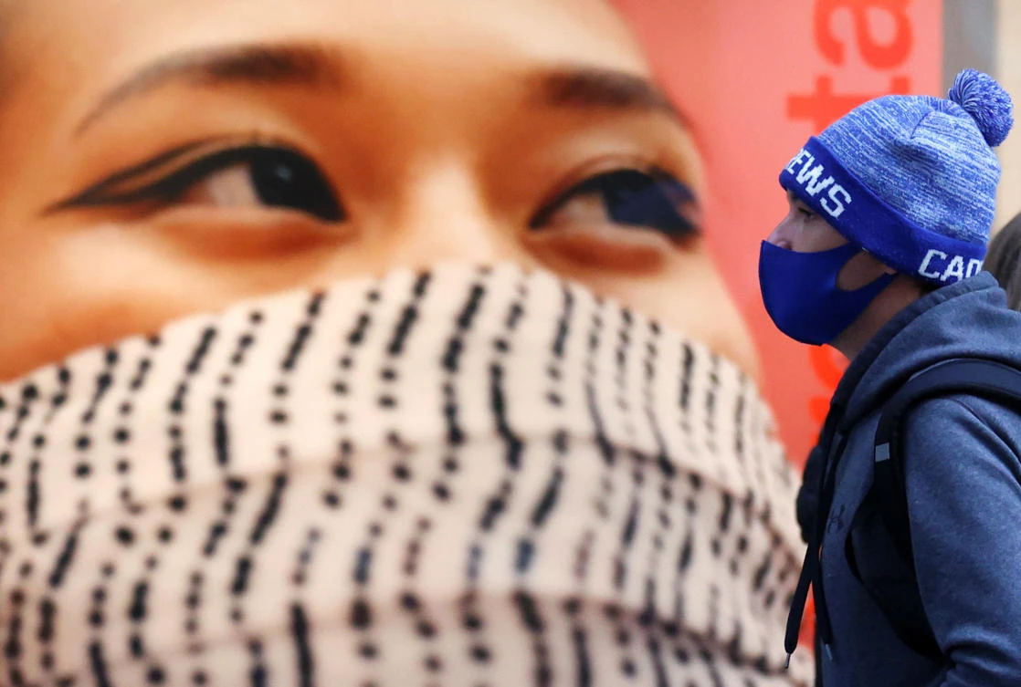 A person wearing a protective face mask walks past an advertisement amid the outbreak of the coronavirus disease (COVID-19), in Liverpool, Britain, October 13, 2020. (Reuters)