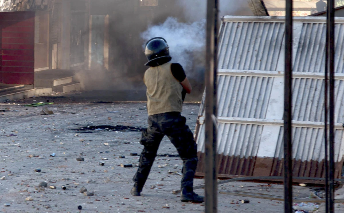 A member of the Tunisian security forces fire tear gas as protesters take to the streets in Sbeitla. (AFP)