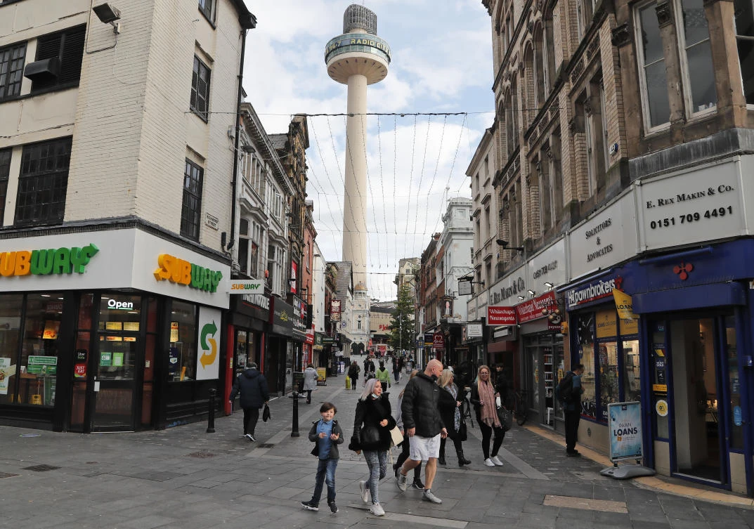 People stroll along a shopping street as new measures across the region are set to come into force in Liverpool, England, Wednesday, Oct. 14, 2020. (AP)