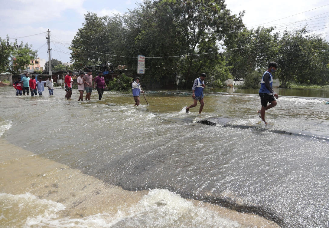 People wade through floodwaters after heavy rainfall at Jillelaguda in Hyderabad, India, Thursday, Oct. 15, 2020. Record rains and heavy flooding in the southern Indian state of Telangana collapsed houses and killed more than a dozen people, police said Wednesday. (AP)