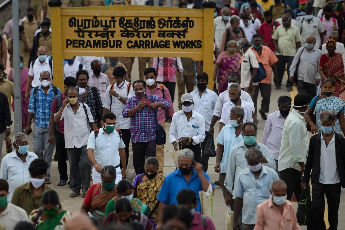 Commuters wearing facemasks to prevent the spread of the Covid-19 coronavirus walk along a platform at a train station in Chennai on October 14, 2020. (AFP)