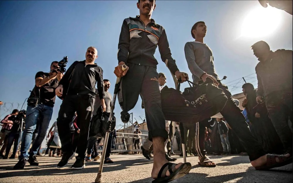 Men leave a Kurdish-run prison in northeast Syria in a general amnesty for low-level Daesh prisoners. (AFP)