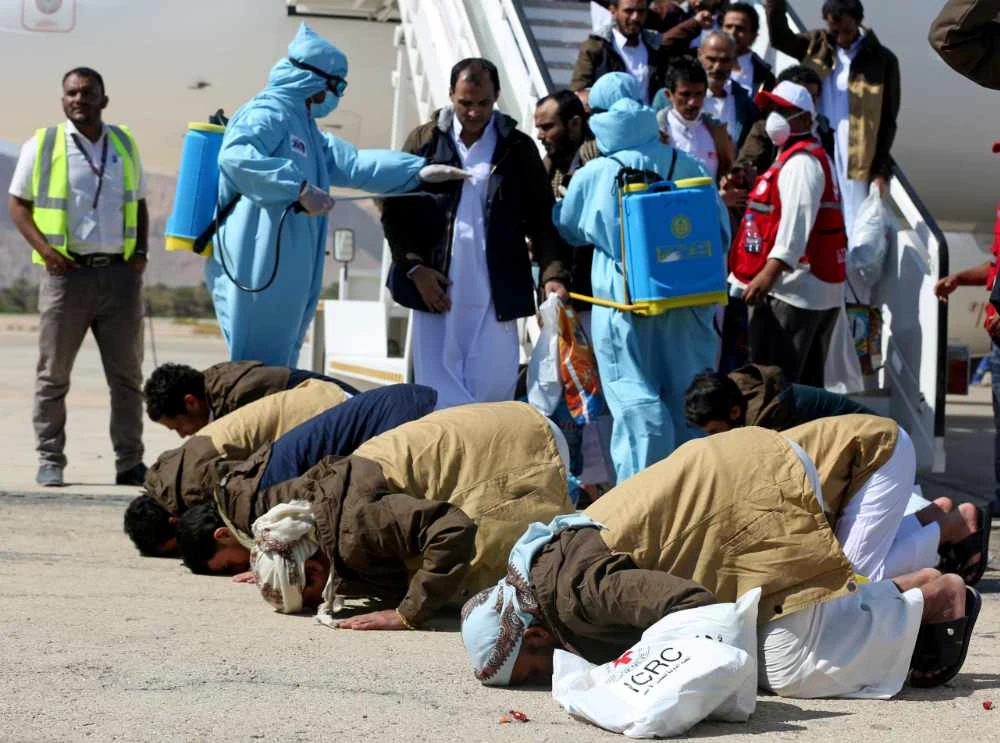 Freed Saudi-led coalition prisoners pray as they arrive at Sayoun airport in Yemen on October 15, 2020 after their release in a prisoner swap. (REUTERS/Ali Owidha)