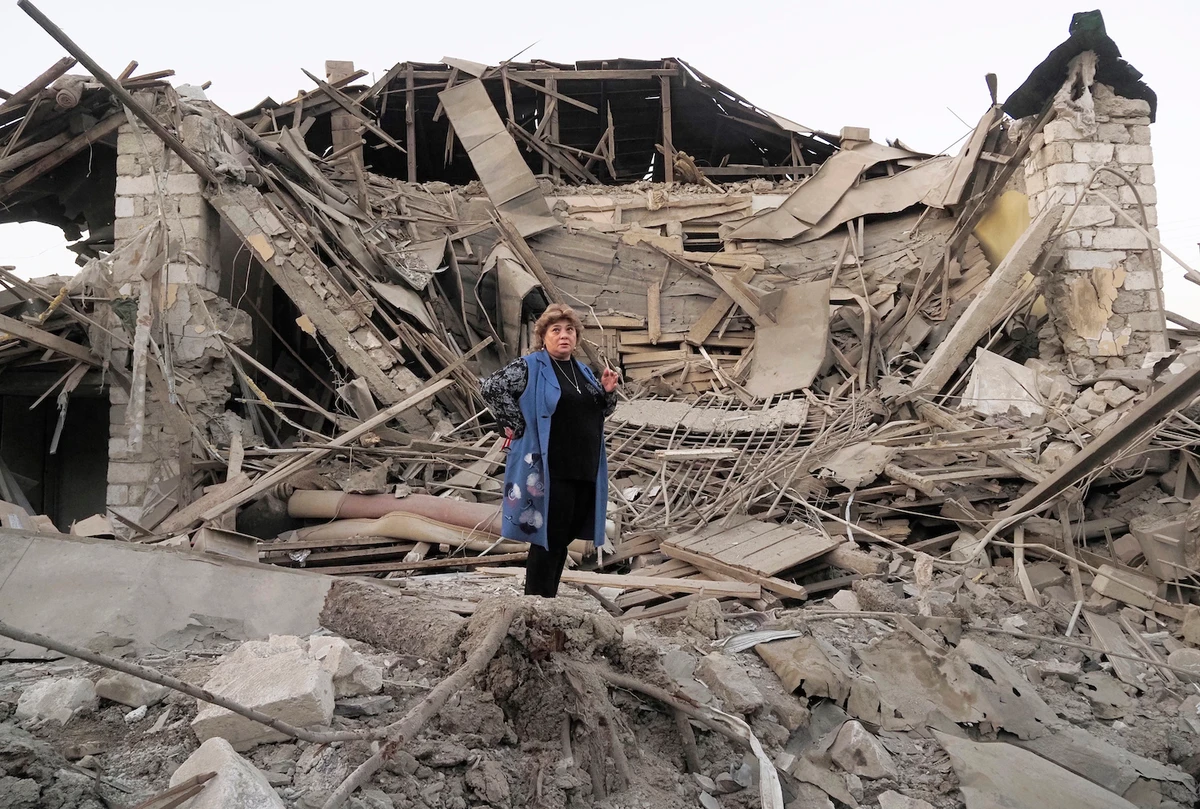 Home owner, Lida Sarksyan, stands near her house destroyed by shelling from Azerbaijan's artillery during a military conflict in Stepanakert, the separatist region of Nagorno-Karabakh, Saturday, Oct. 17, 2020. (AP)