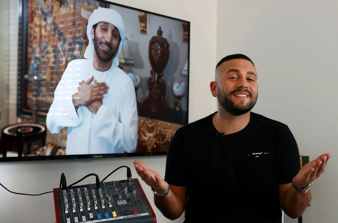Israeli singer Elkana Marziano, 28, speaks during an interview with AFP at his home in the central Israeli city of Giv'at Shmuel, in front of a screen showing the video clip of a song on which he worked in collaboration with Emirati artist Walid Aljasim (image on screen), on October 15, 2020. (AFP)