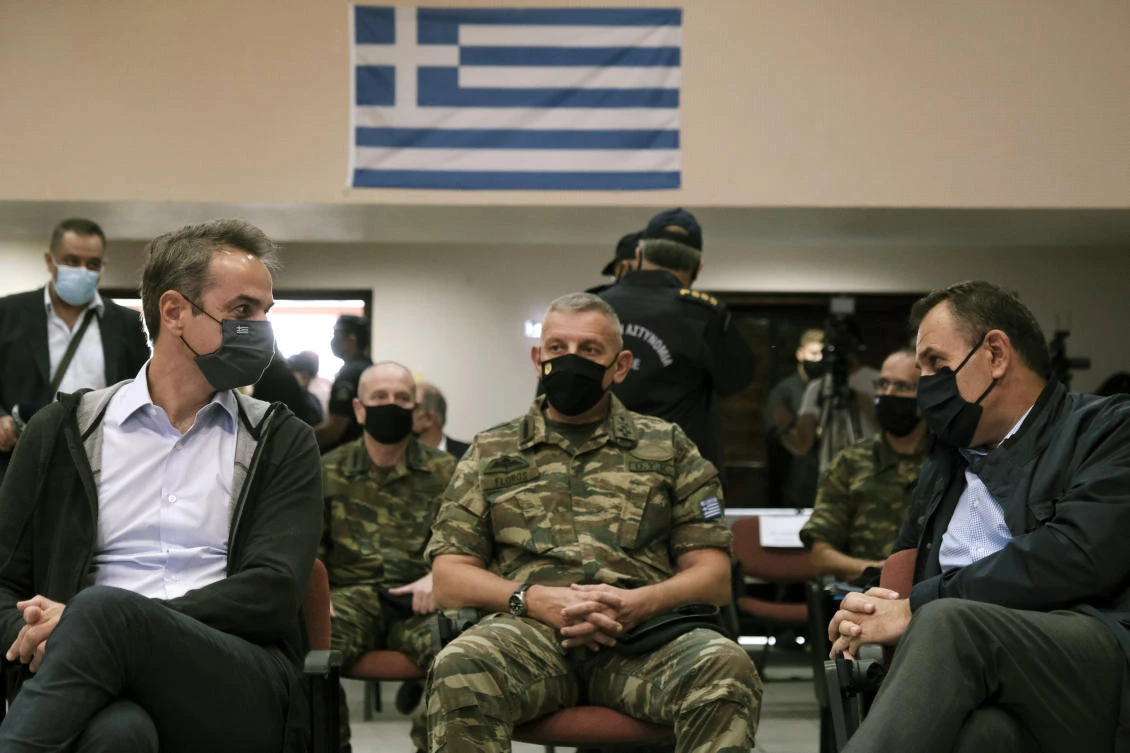 Greece's Prime Minister Kyriakos Mitsotakis, left, Greek Defense Minister Nikos Panagiotopoulos, right, and Armed Forces chief Lt. Gen. Konstantinos Floros, attend a presentation of the proposed construction of a new part of a fence which will be built at the border with Turkey, in Alexandroupolis, northern Greece, Saturday, Oct. 17, 2020. (AP)