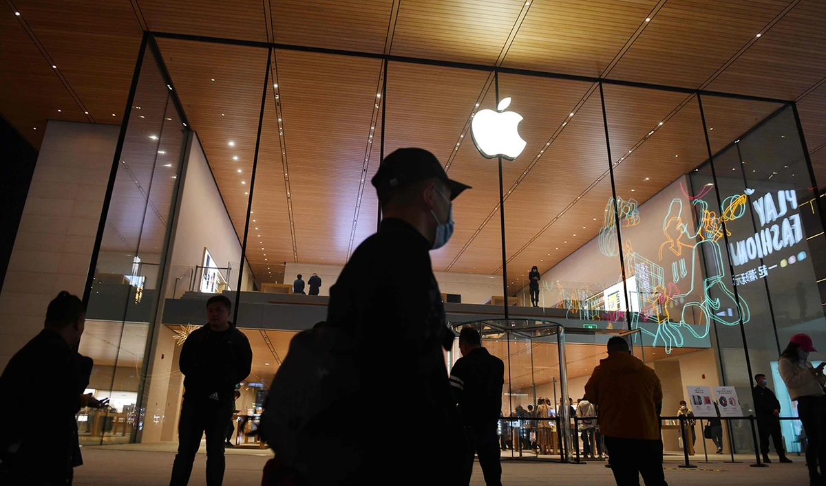 People walk past an Apple store in Beijing on October 19, 2020. (AFP)