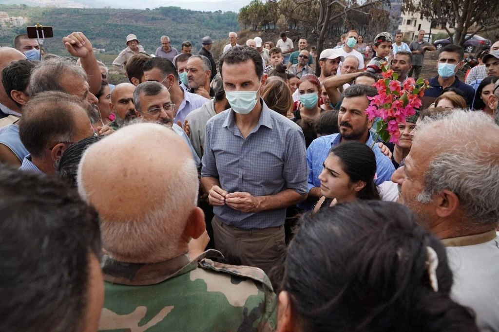 Above, president Bashar Al-Assad tours the village of Mashtal Helo in the Syrian Mediterranean port of Tartus. (AFP file photo)