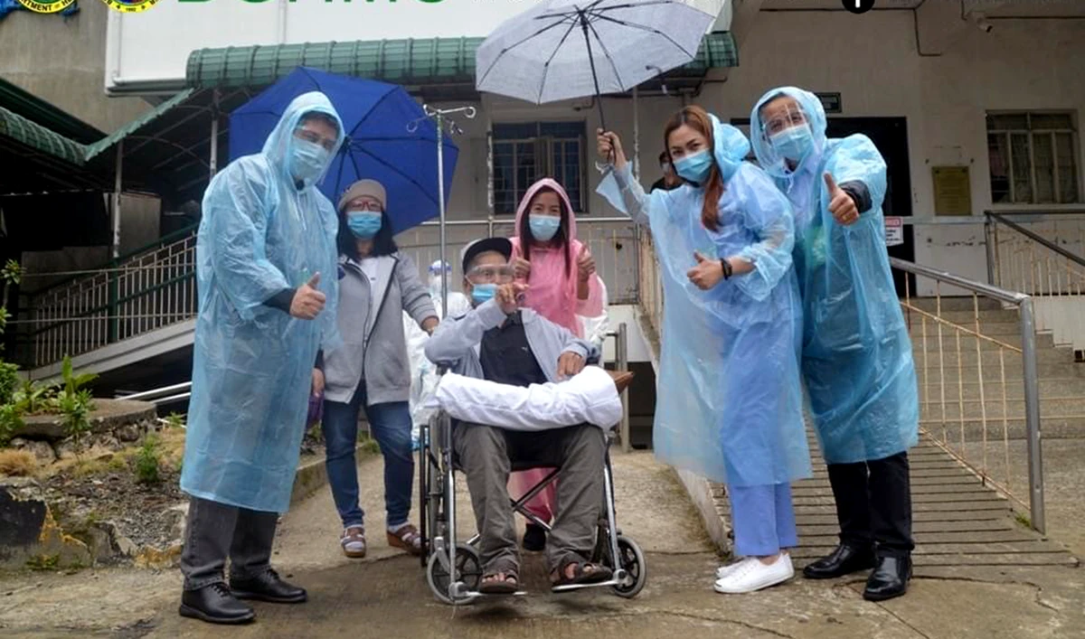 Baguio General Hospital and Medical Center (BGHMC) staff pose for a photograph with their 106-year-old COVID-19 recoveree in Baguio City on Tuesday. (Photo courtesy: BGHMC)