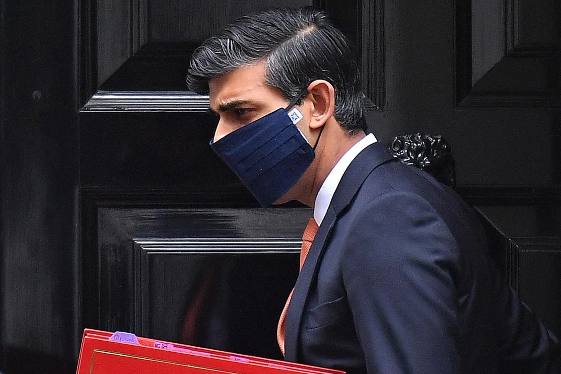 Britain's Chancellor of the Exchequer Rishi Sunak, wearing a face mask or covering due to the COVID-19 pandemic, leaves from 11 Downing Street in London on October 20, 2020. (AFP)