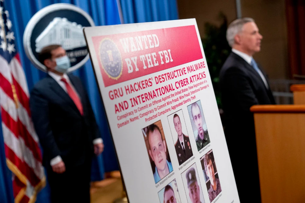 A poster showing six wanted Russian military intelligence officers is displayed at a news conference at the US Department of Justice in Washington, D.C., on Oct. 19, 2020. (AP Photo/Andrew Harnik, pool)