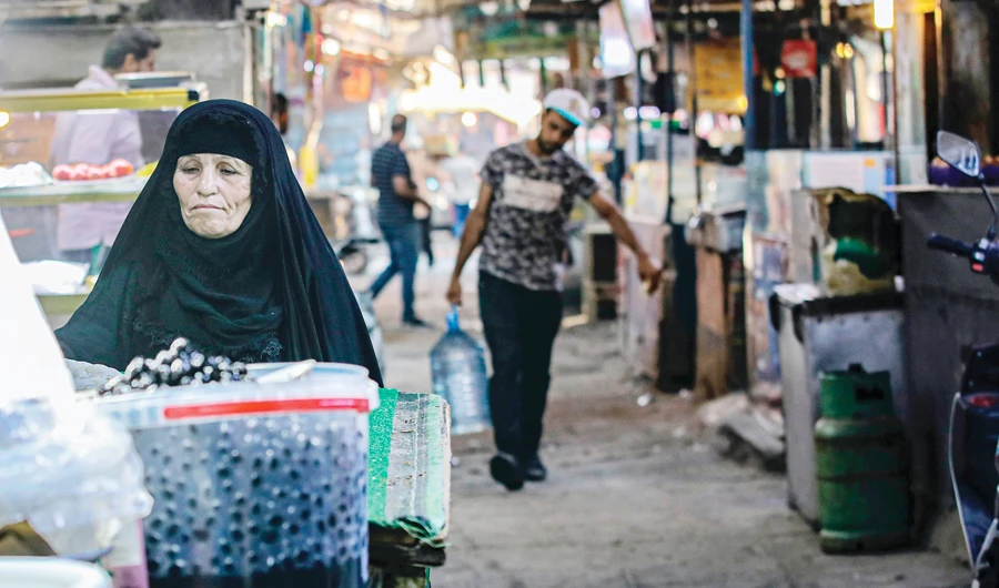 A woman street vendor waits for customers in Basra. Iraq faces a liquidity crisis as the cash-strapped state struggles to pay public sector salaries and import essential goods while oil prices remain low. (AP)