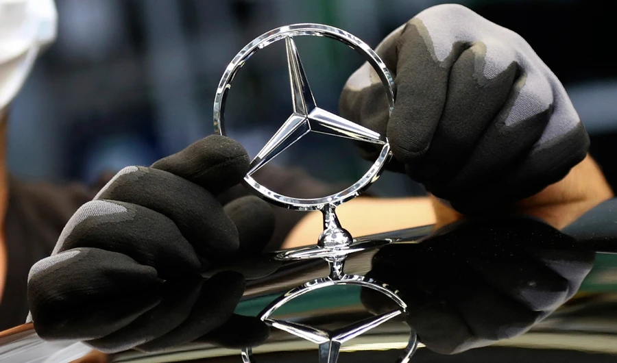 In this Thursday, April 30, 2020 file photo, an employee attaches a Mercedes emblem as he works on a Mercedes-Benz S-class car at the Mercedes plant in Sindelfingen, Germany. (AP)