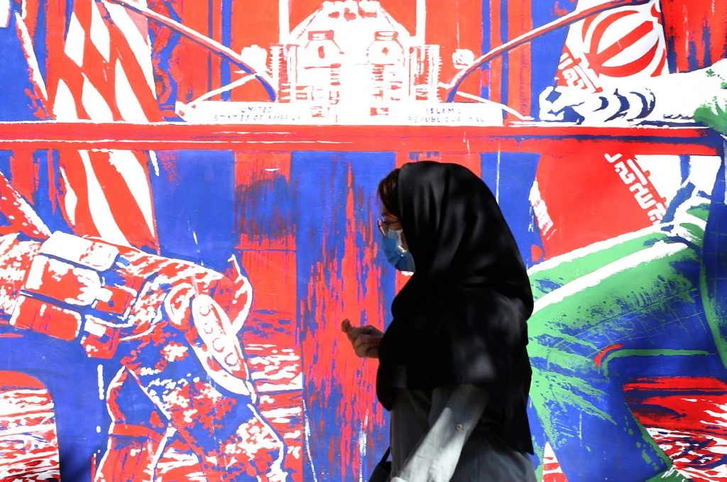 A woman walks past a mural painted on the outer walls of the former US embassy in the Iranian capital Tehran, on September 29, 2020. (AFP/File)