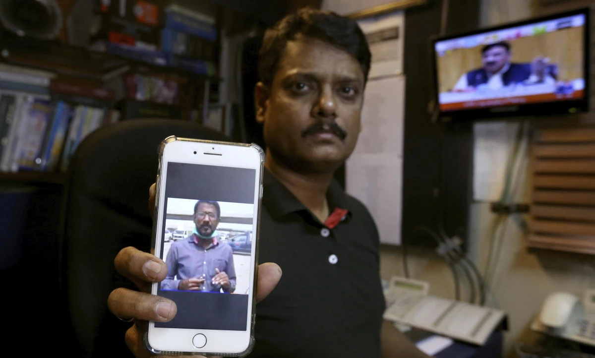 Fahim Siddiqi, Karachi bureau chief of Geo News television, shows the picture of missing colleague Ali Imran Syed, at his office in Karachi, Pakistan, Saturday, Oct. 24, 2020. (AP)