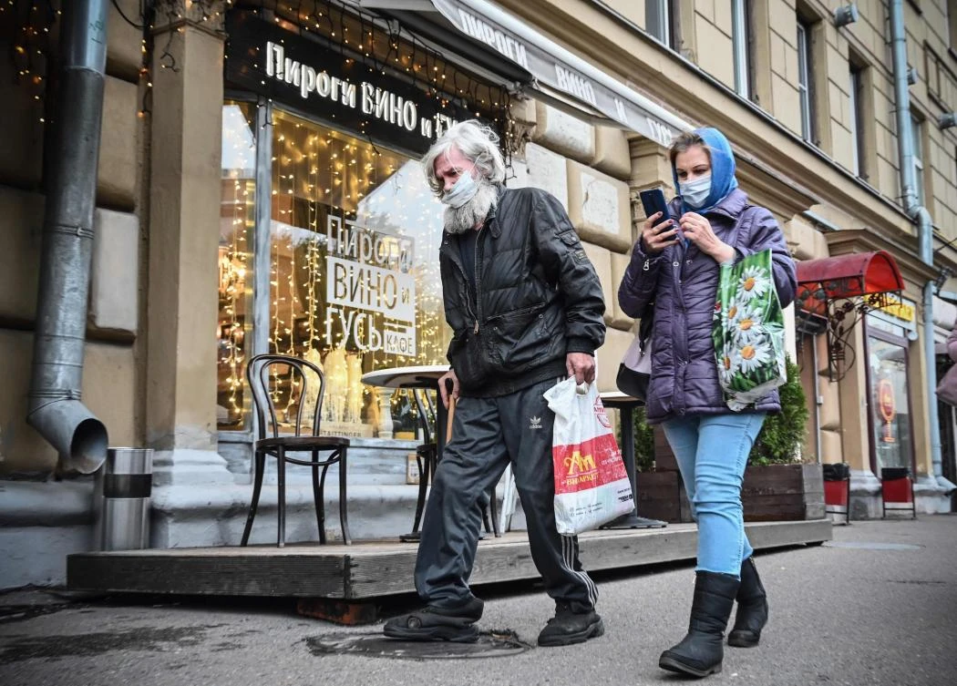 People wearing face masks walk along a street in downtown Moscow on October 22, 2020, amid the ongoing COVID-19 coronavirus pandemic. Russia confirmed 15,971 new Covid-19 cases on October 22, 2020. (AFP)