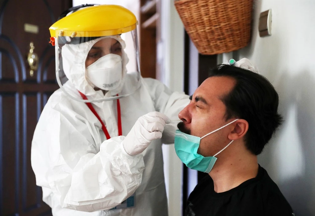 A health worker taking a nasal swab for a COVID-19 screening on a man in Ankara. (File/AFP)