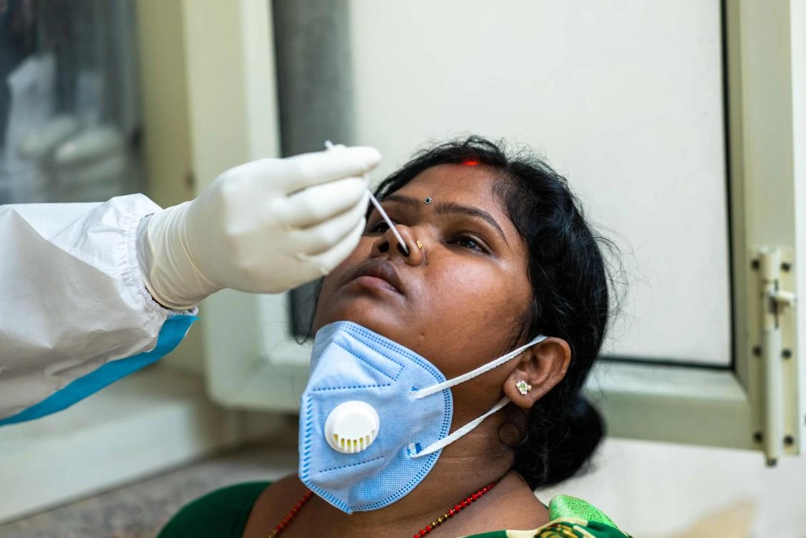 A medical worker collects a swab sample from a woman at a Covid-19 coronavirus screening site in New Delhi on October 29, 2020. (AFP)