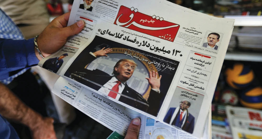 An Iranian looks at a newspaper with a picture of US President Donald Trump on the front page, as the people’s interest in the presidential poll outcome soar in the country. (AFP)
