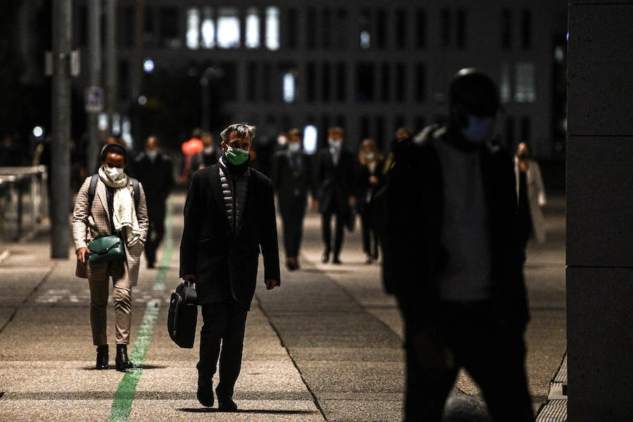 People walk by high-rise buildings during the evening rush hour at the business district of La Defense west of Paris on October 21, 2020, as the country faces a new wave of infections to the Covid-19 (the novel coronavirus). (AFP)